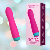 A pink Femme Funn Rora Rotating Bullet Vibrator with a light blue base stands next to its packaging, which reads "FemmeFunn Power Innovation Fun RORA Liquid Silicone Rotating Bullet Vibrator." The background is a soft, blurred mix of light colors, highlighting the elegance of this liquid silicone wonder with 360° rotation.
